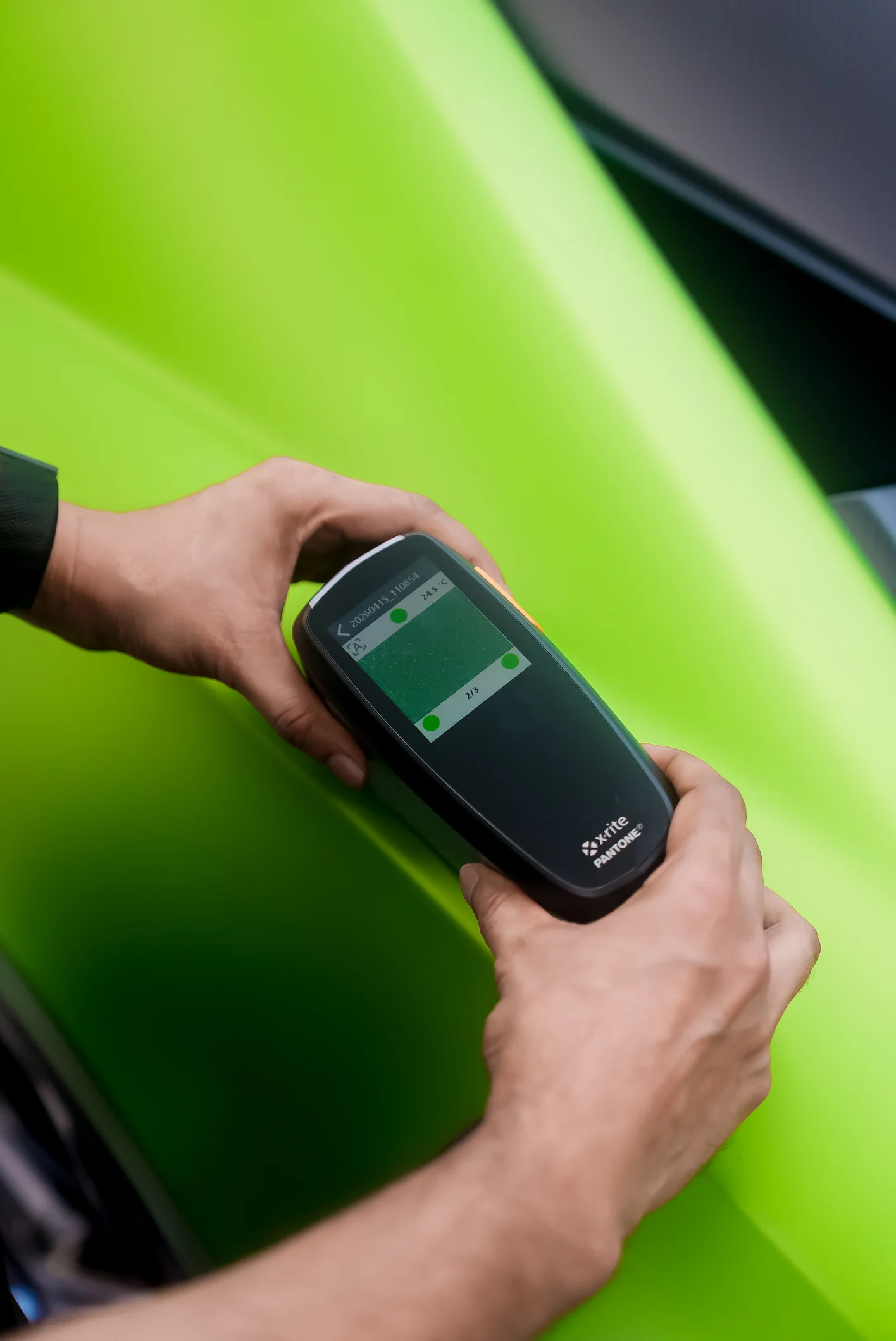 Technician using Numix spectrophotometer to measure luxury car paint